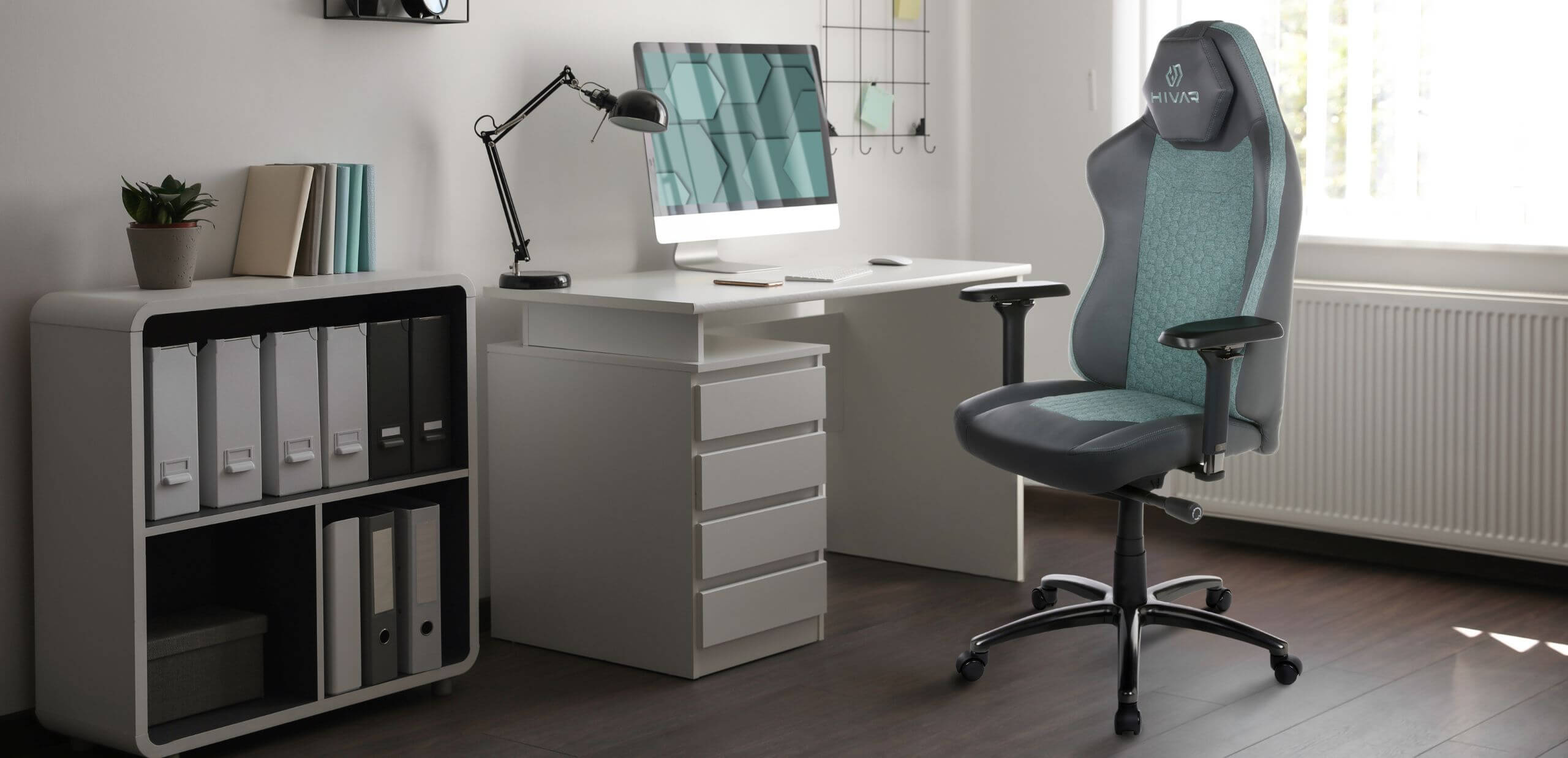 HIVAR Orbical Aurora türkis / anthrazit Farben Bürostuhl vor einem weißen Schreibtisch